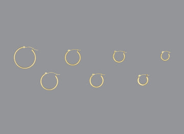 A collection of hoop earrings in ascending size order, made of 14KY gold, displayed against a grey background.
