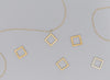 A collection of square-shaped invisible clasps in various metallic finishes arranged on a surface with chain links.