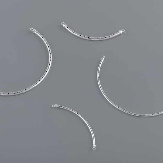 A set of curved bangle wires with rivets on a grey background, used for crafting purposes in jewelry making.