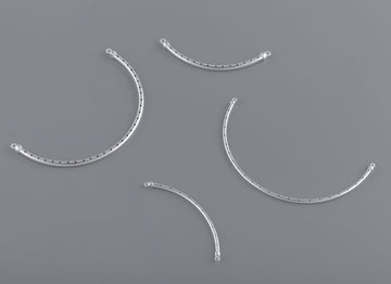 A set of curved bangle wires with rivets on a grey background, used for crafting purposes in jewelry making.