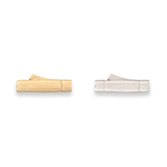Two metallic objects, one gold and one silver, on a white background