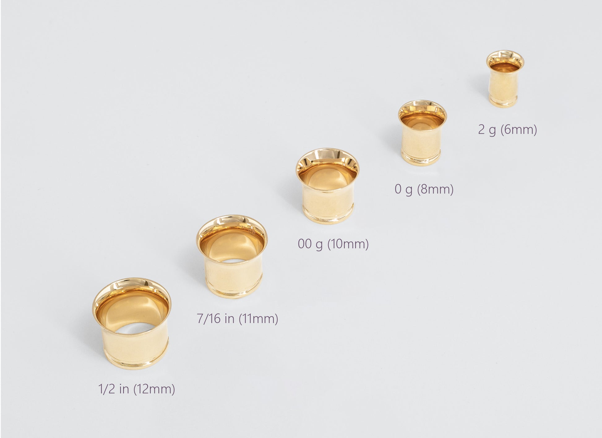 Set of gold gauges with size labels on a light gray background