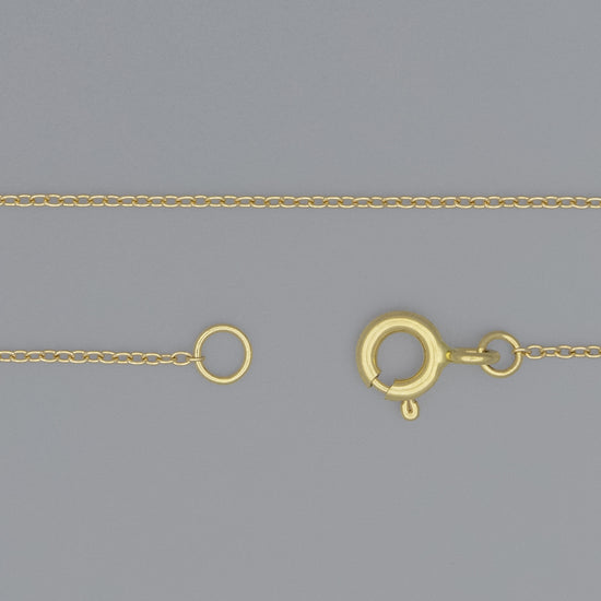 A 0.9mm cable chain necklace with a spring ring clasp and jump rings, displayed on a grey background.