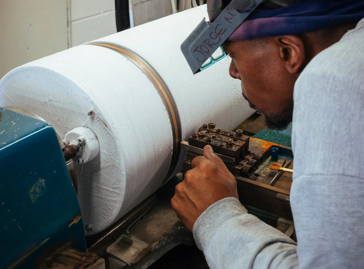 Person operating a large chain machine with a focus on the equipment and task.