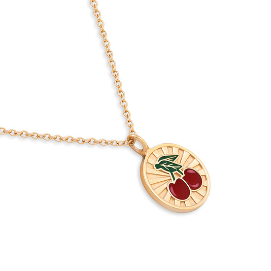 Gold necklace with a cherry pendant on a white background