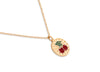 Gold necklace with a cherry pendant on a white background
