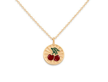 Gold necklace with a cherry pendant on a white background