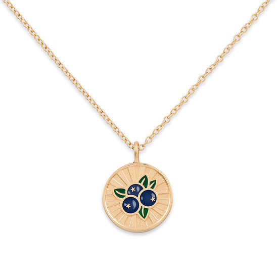 Gold necklace with a circular pendant featuring blueberries on a white background