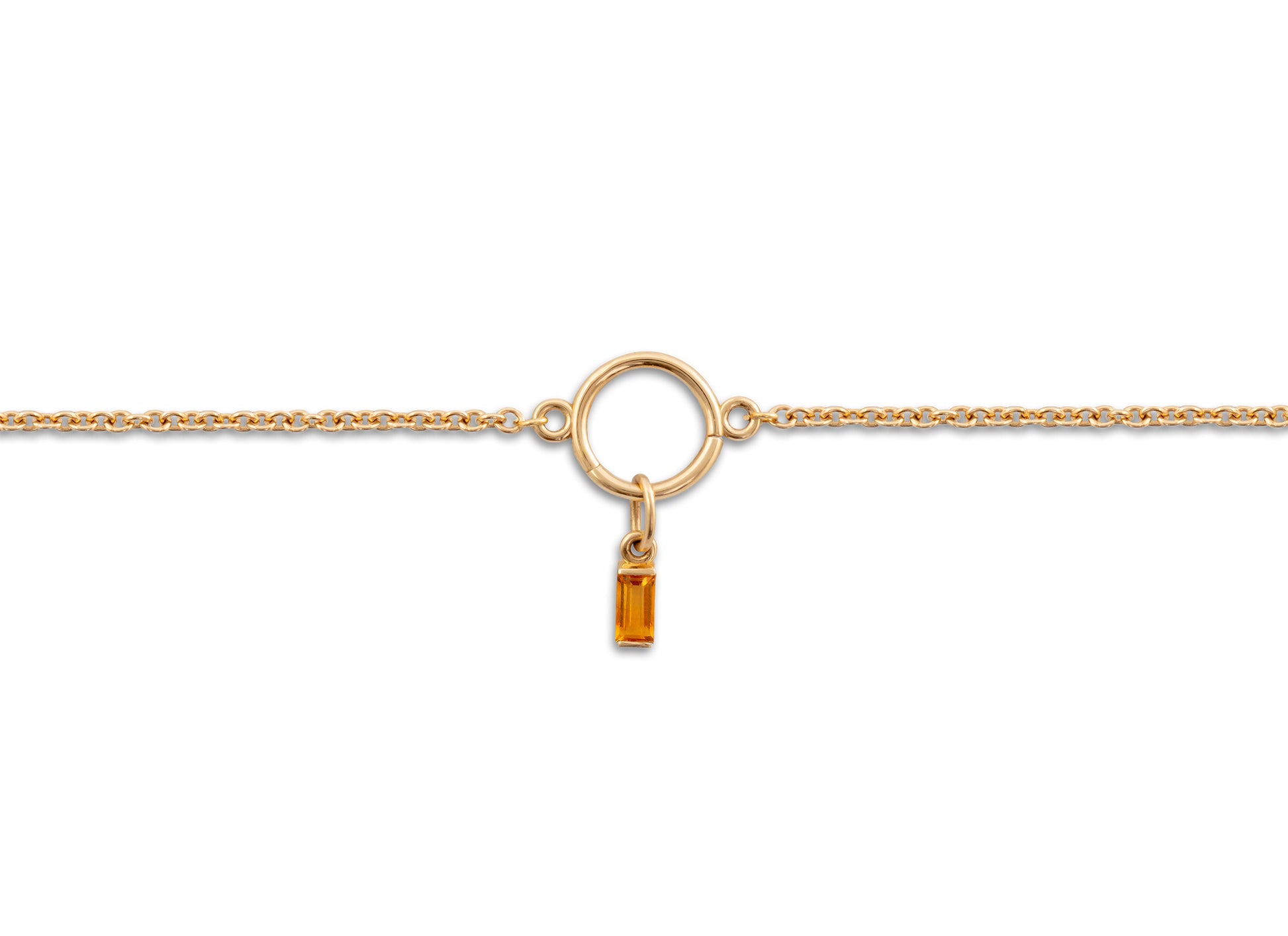 Gold necklace with a small yellow gemstone pendant on a white background.
