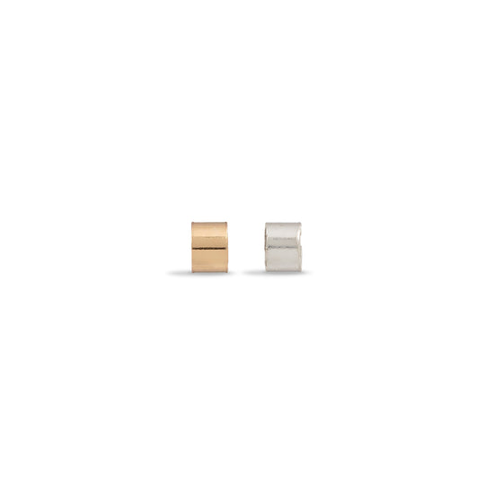Two small cylindrical containers, one gold and one silver, on a white background.