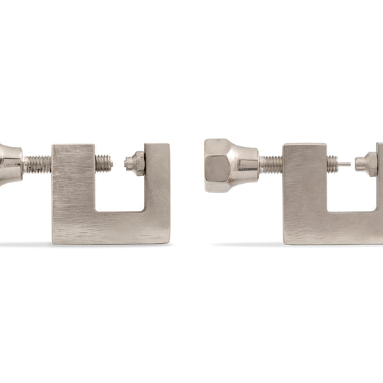 Two metal permanent jewelry hand tools on a white background