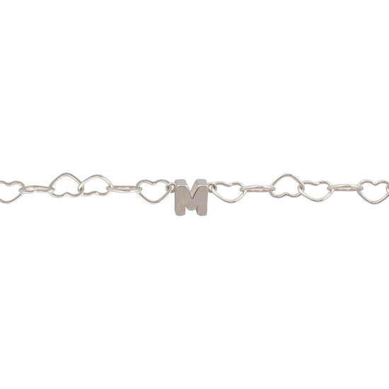 Silver bracelet with heart links and a letter 'M' charm on a white background.