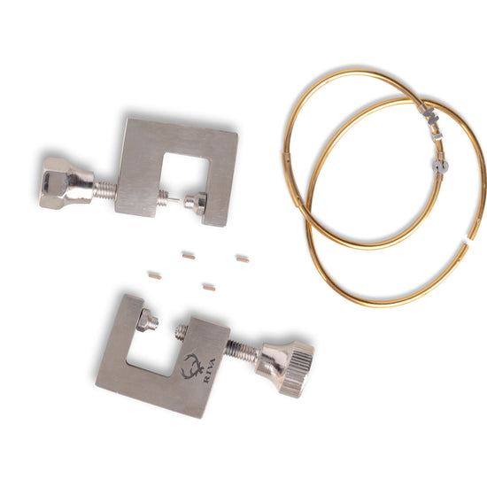 Two metal tools with gold permanent bangles on a white background