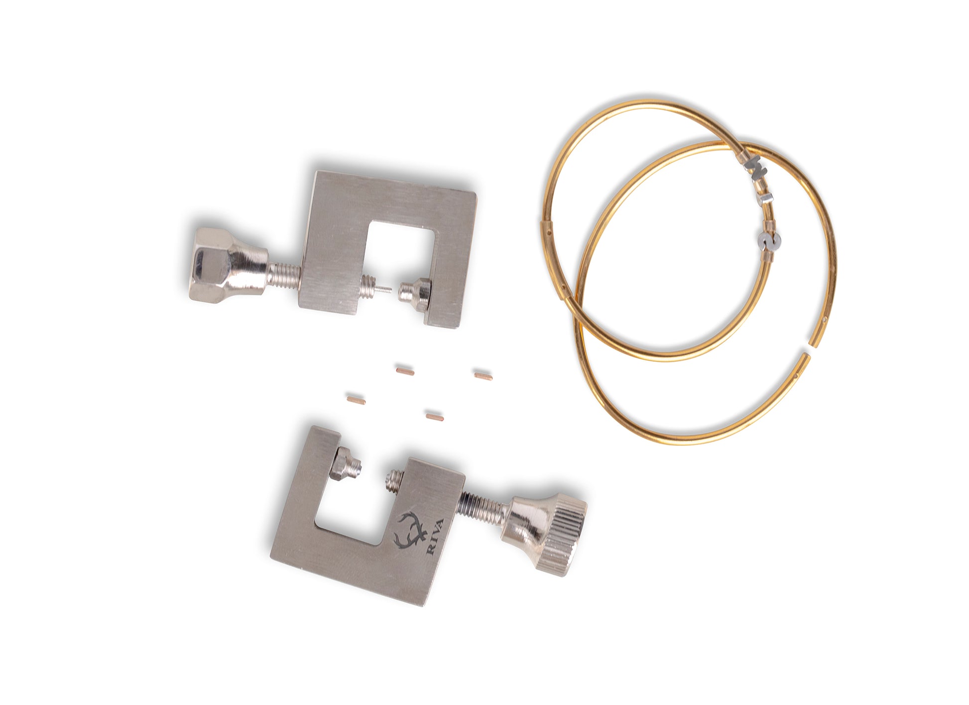 Two metal tools with gold permanent bangles on a white background