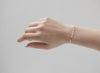 A person's hand wearing a silver hammered cable chain bracelet.