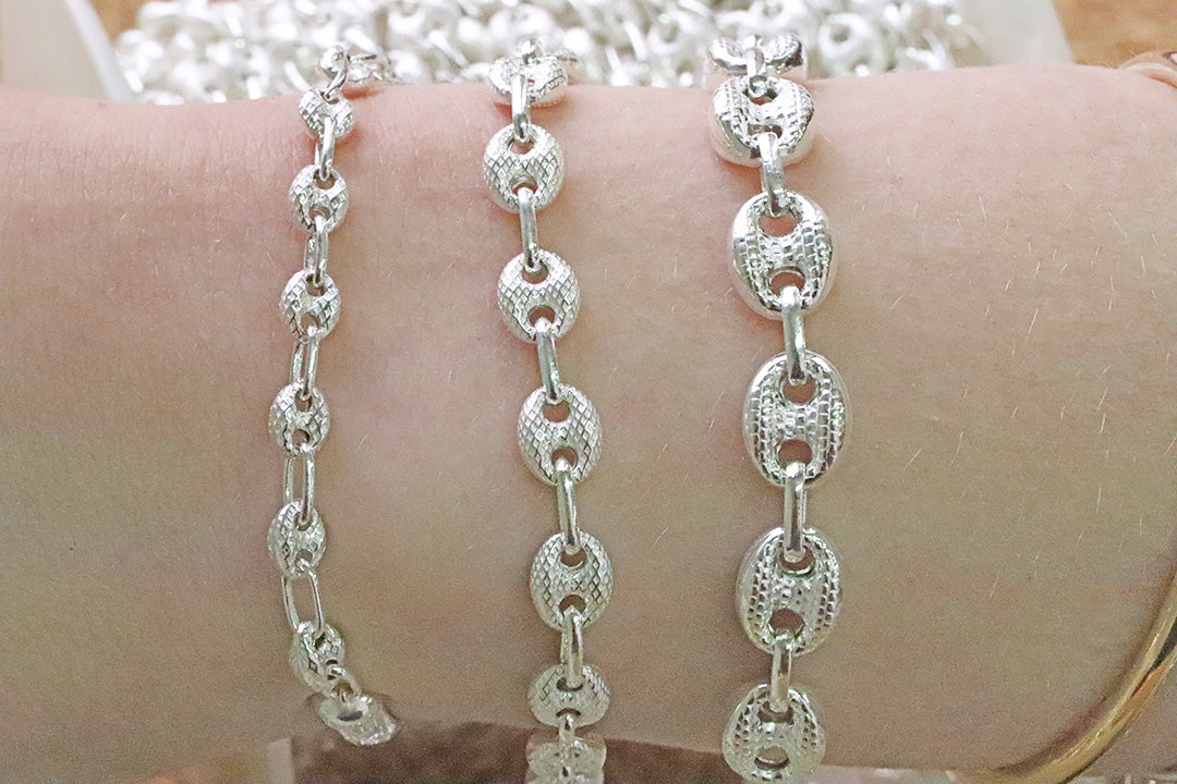 Silver chain mariner bracelet on a wrist with a blurred background