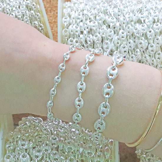 Silver chain bracelet on a wrist with a blurred background
