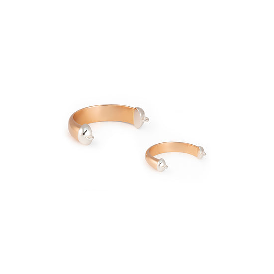 Gold bangle rings with pearl-like beads on a white background