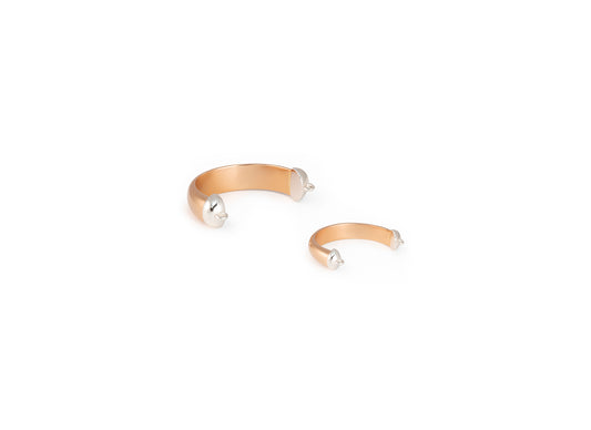 Gold bangle rings with pearl-like beads on a white background