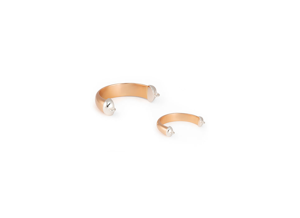 Gold bangle rings with pearl-like beads on a white background