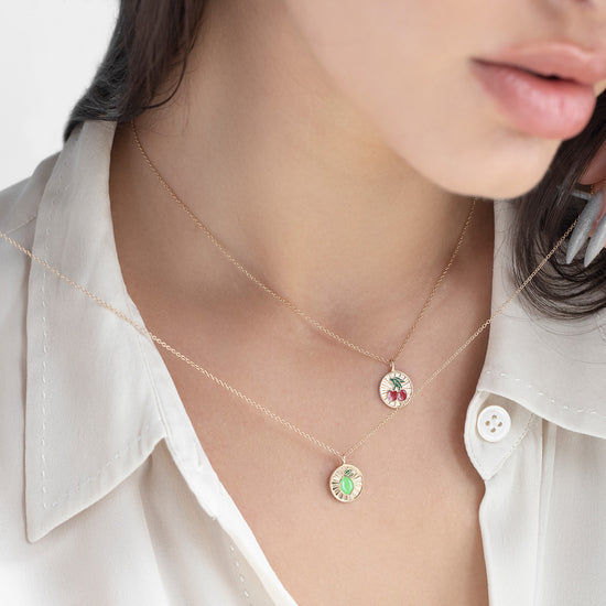 Close-up of a person wearing a delicate necklace with small pendants.