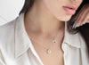 Close-up of a person wearing a delicate necklace with small pendants.