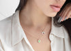 Close-up of a person wearing a delicate necklace with small pendants.