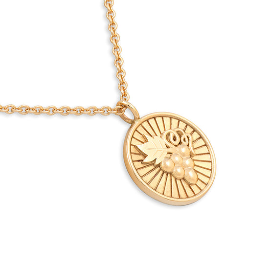 Gold necklace with a round pendant on a white background