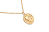 Gold necklace with a round pendant on a white background