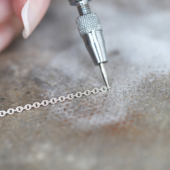 Jewelry link opener tool being used on a chain