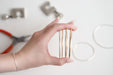 Hand holding wired gold bangles with blurred background