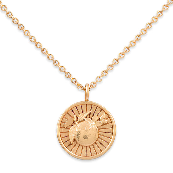 Gold necklace with a round pendant on a white background